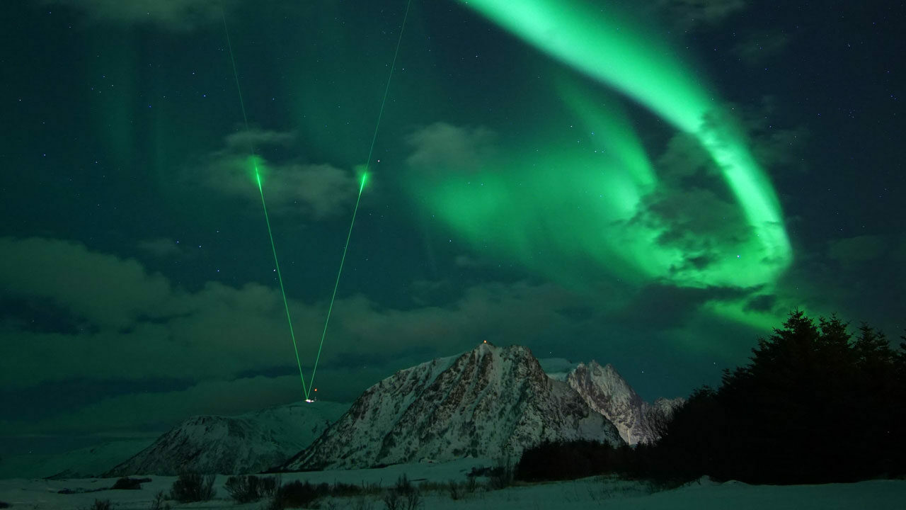 Toppbildet viser Nordlys tatt på Andøya med laserstråler ut i rommet fra ALOMAR-observatoruet. Bildet er tatt av Laura-Kristin Scholtz og brukt med tillatelse av fotograf.